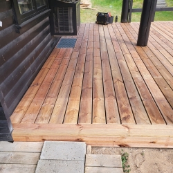 nybygget træterrasse i trykimprægneret træ ved sort sommerhus