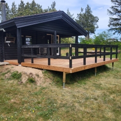 Træterrasse ved sort hus