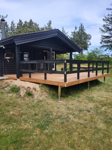 Træterrasse ved sort hus